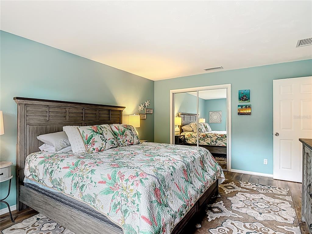 4748 Dixie Drive Ponce Inlet, FL 32127 - Photo 33 of 53 a bedroom with a large bed and wooden floor