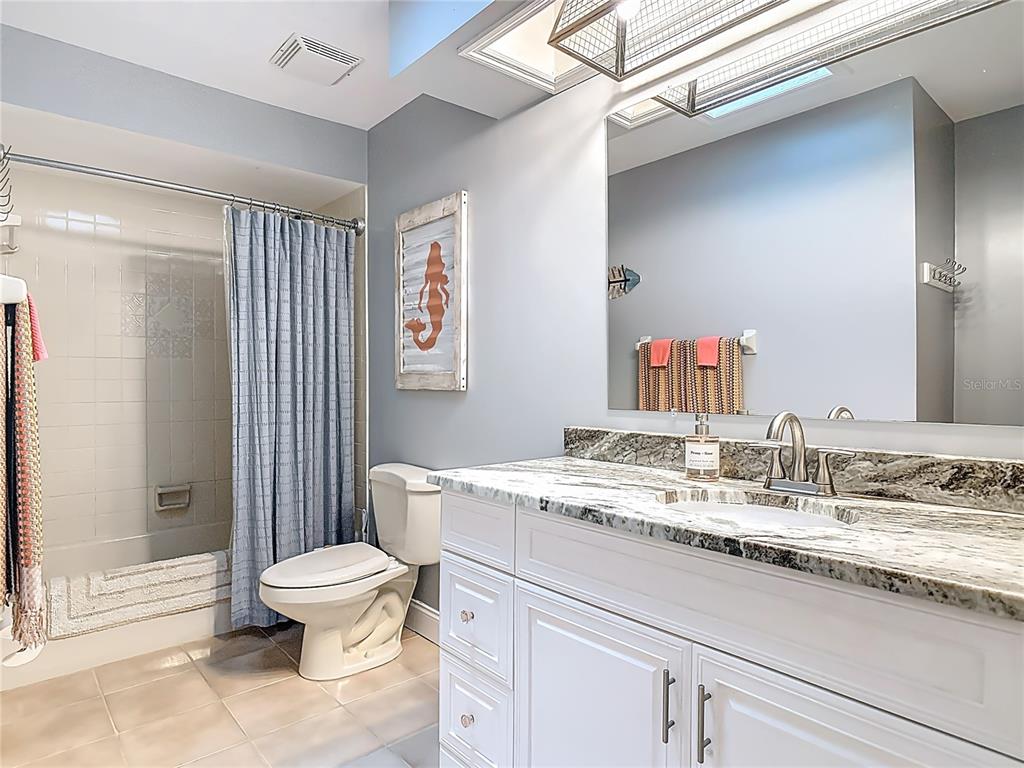 4748 Dixie Drive Ponce Inlet, FL 32127 - Photo 34 of 53 a bathroom with a granite countertop sink mirror vanity and toilet