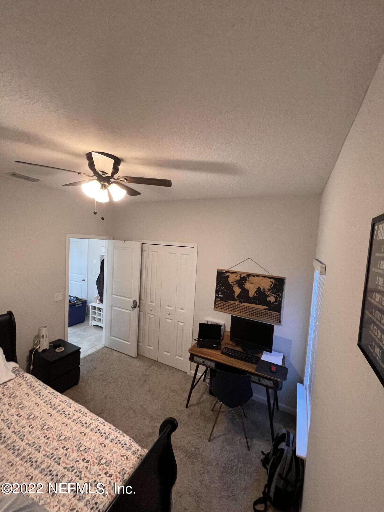 171 Ferndale Way St. Augustine, FL 32092 - Photo 24 of 35 a bedroom with a bed and a chandelier