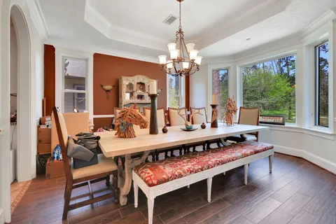 a view of a dining room with furniture a chandelier and wooden floor