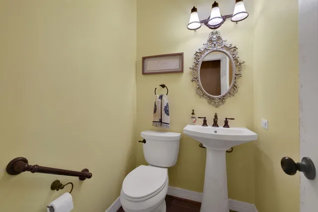 a bathroom with a toilet sink and mirror