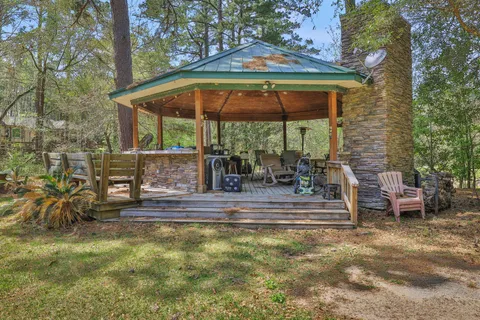 a view of backyard with table and chairs under an umbrella