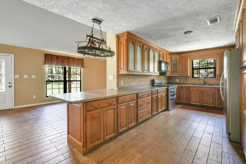 a kitchen with stainless steel appliances granite countertop wooden floors and sink
