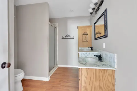 a bathroom with a granite countertop sink toilet and mirror