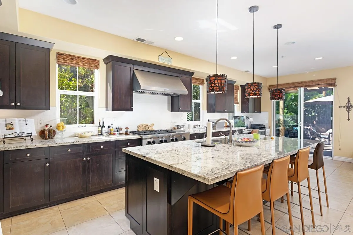 1938 Sheridan Road Encinitas, CA 92024 - Photo 3 of 14 a kitchen with kitchen island granite countertop a sink a counter top space appliances and cabinets