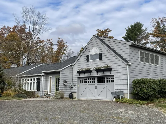 a view of house with outdoor space and trees in the background
