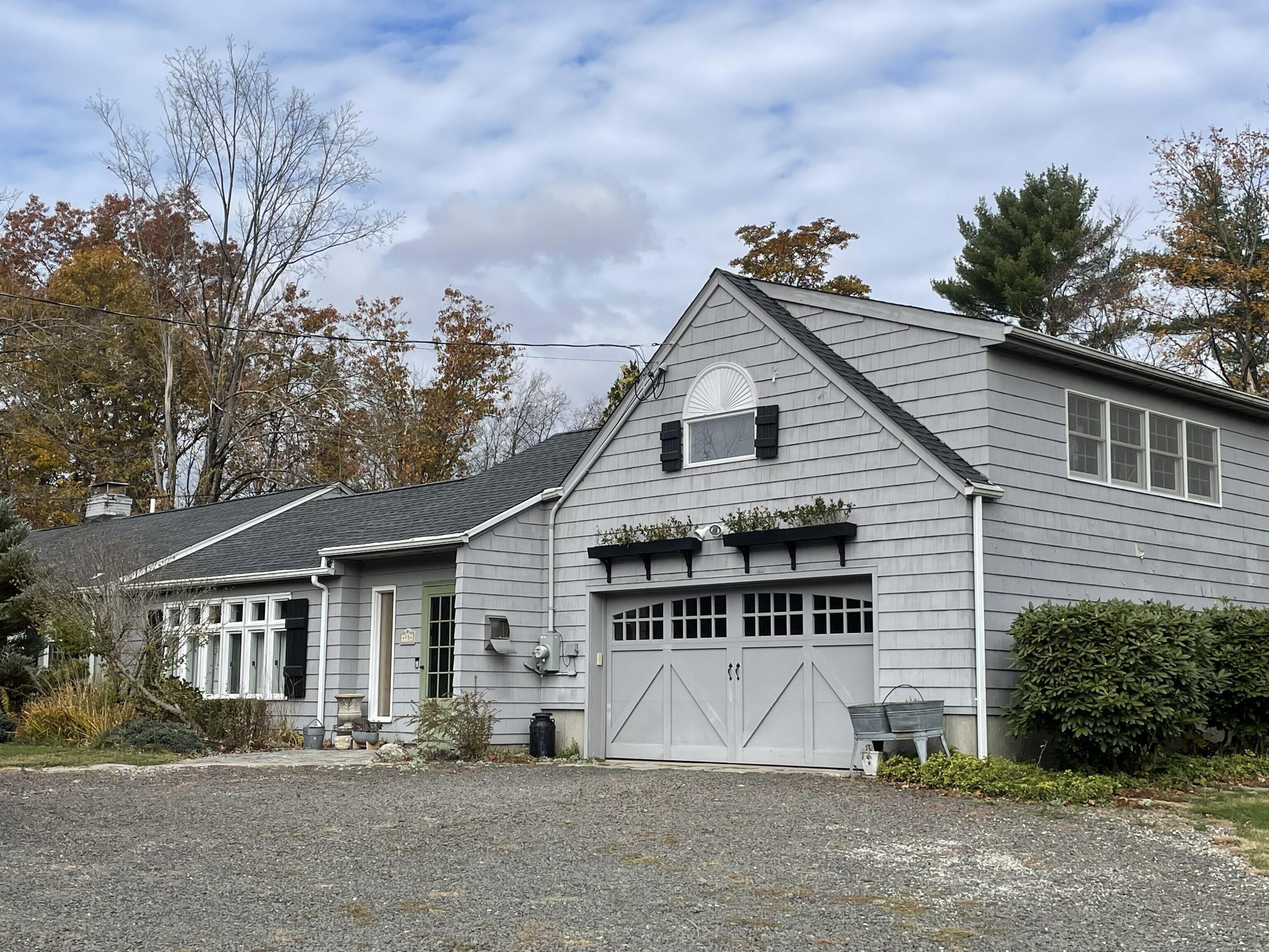 a view of house with outdoor space and trees in the background