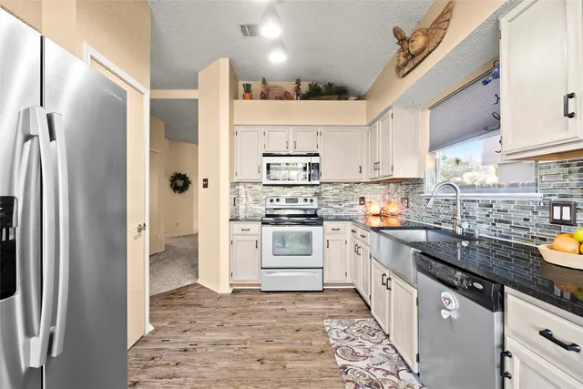 a kitchen with stainless steel appliances a refrigerator sink and microwave