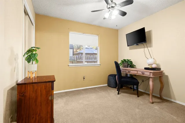 a view of a workspace with furniture and a window