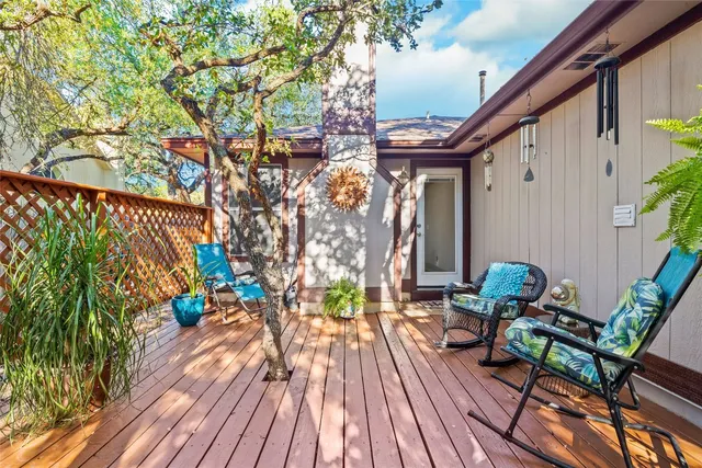 a balcony with wooden floor table and chairs