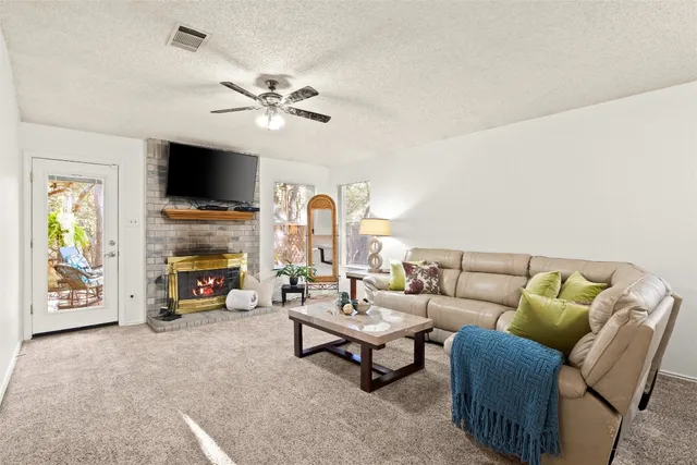 a living room with furniture a flat screen tv and a fireplace