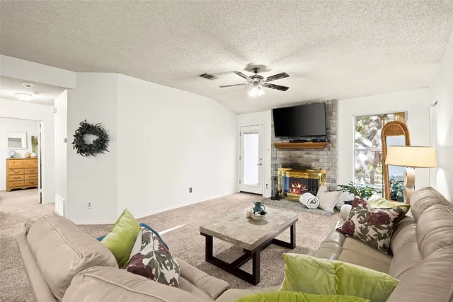 a living room with furniture a flat screen tv and a fireplace