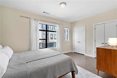 a bedroom with a bed and a dresser with mirror