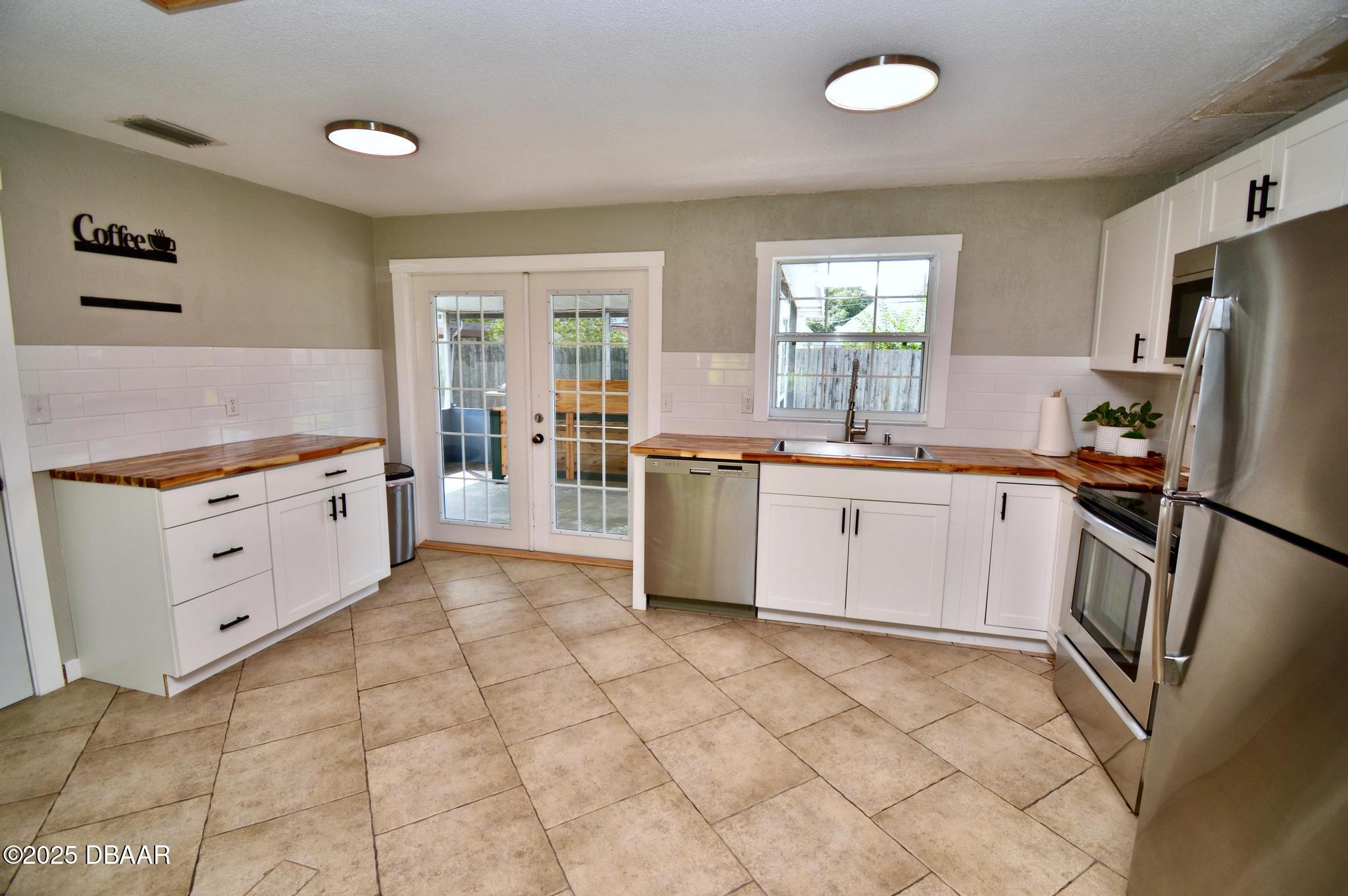 1025 2nd Street Port Orange, FL 32129 - Photo 19 of 33 a kitchen with stainless steel appliances a stove sink and refrigerator