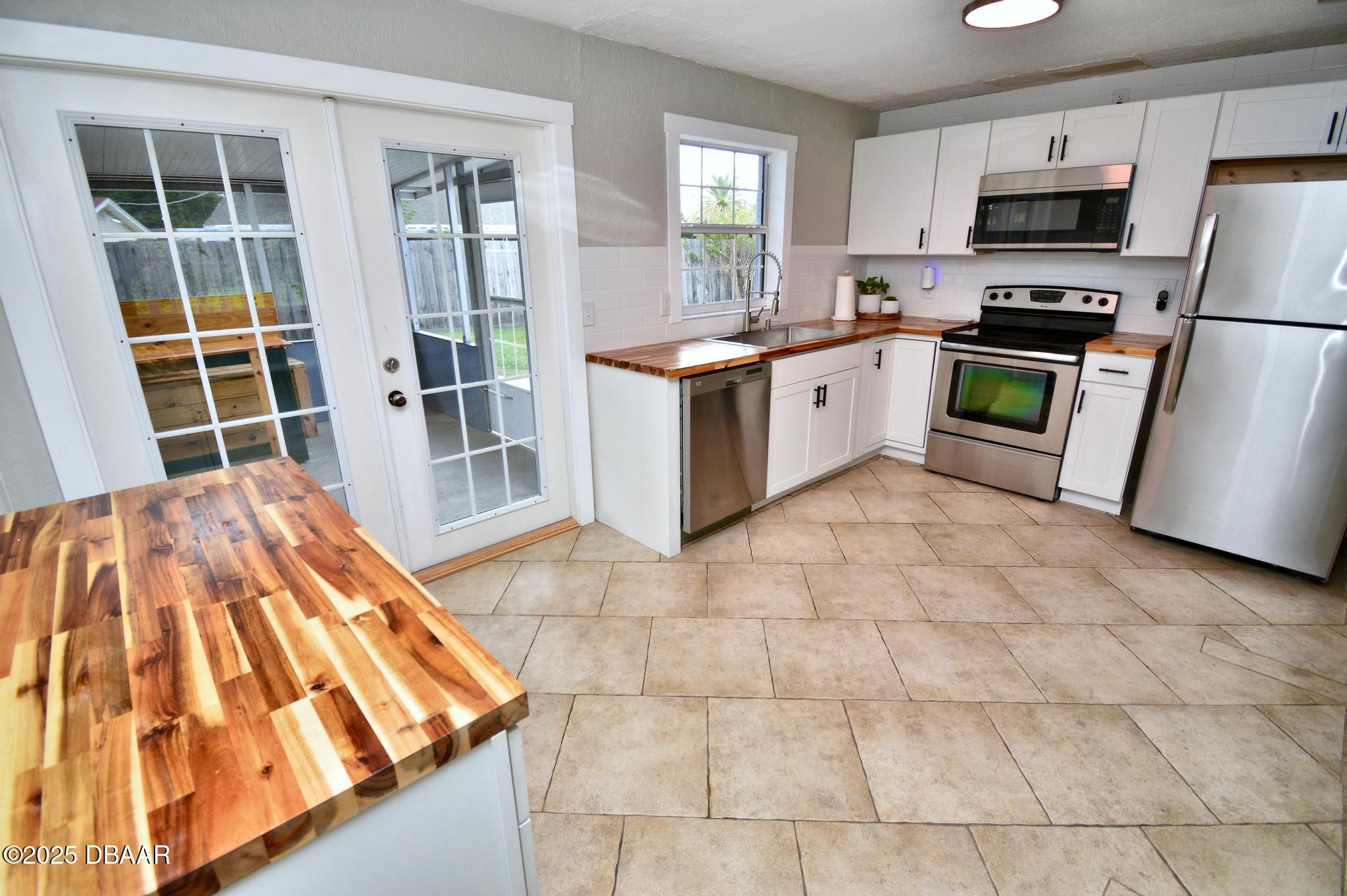 1025 2nd Street Port Orange, FL 32129 - Photo 21 of 33 a kitchen with stainless steel appliances a stove a sink and a refrigerator