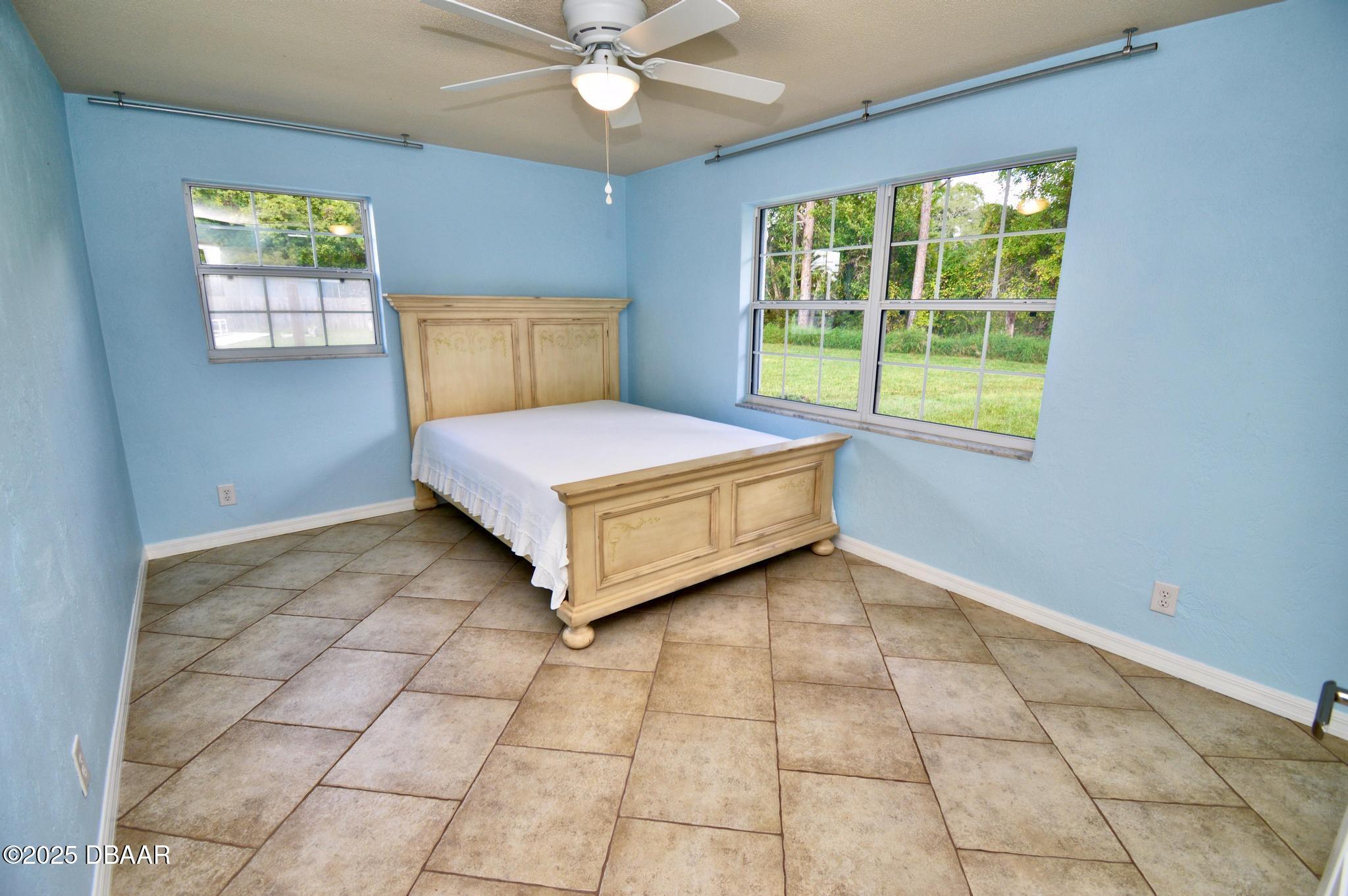 1025 2nd Street Port Orange, FL 32129 - Photo 24 of 33 a spacious bedroom with a bed and window