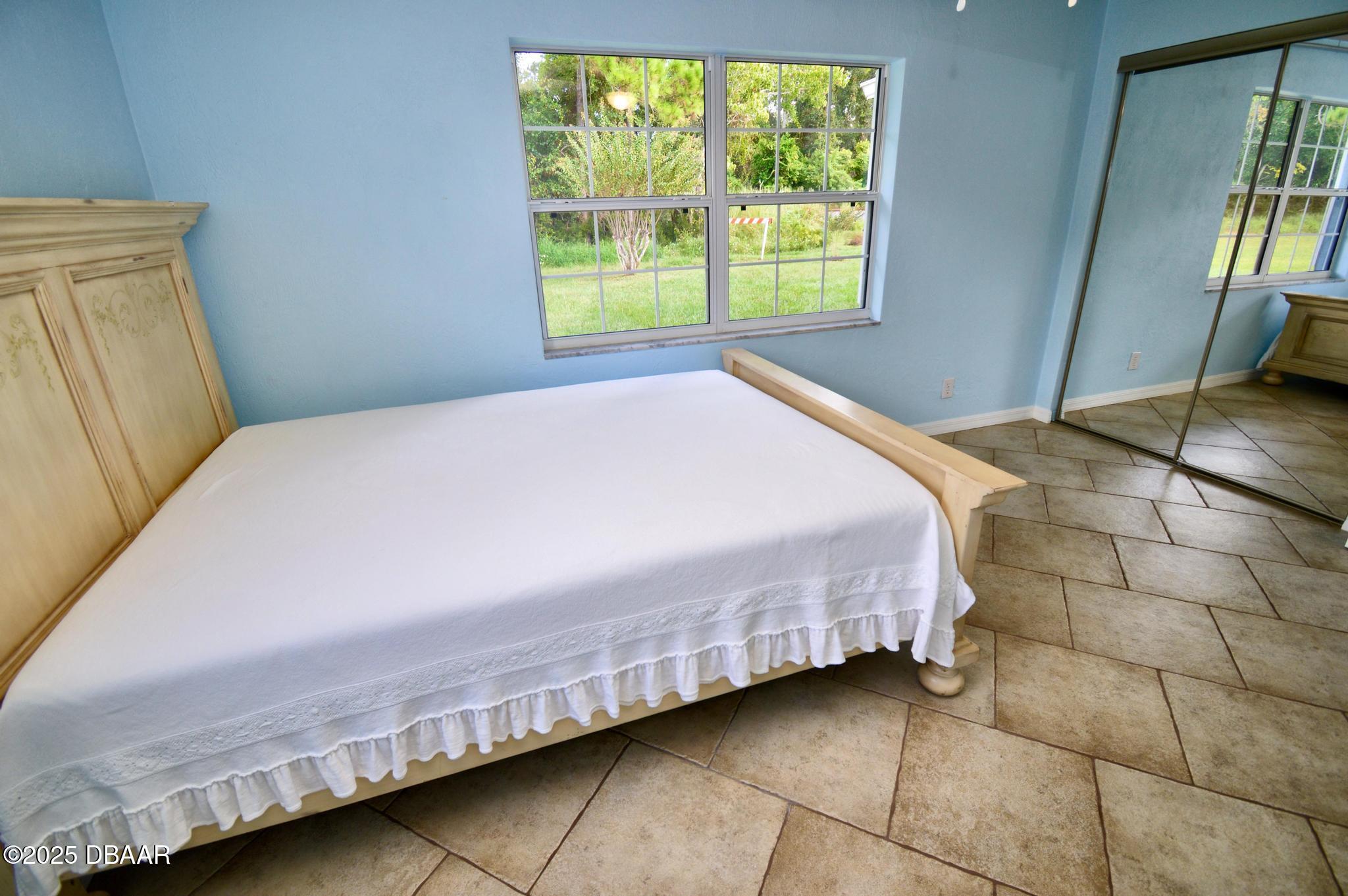 1025 2nd Street Port Orange, FL 32129 - Photo 25 of 33 a bedroom with a bed and a mirror