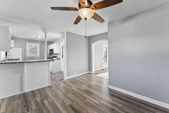 a kitchen with granite countertop a sink stove refrigerator and cabinets