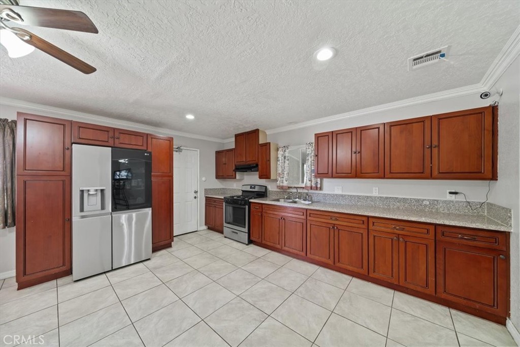 20548 Neuralia Road California City, CA 93505 - Photo 22 of 49 a large kitchen with stainless steel appliances granite countertop a refrigerator and a sink
