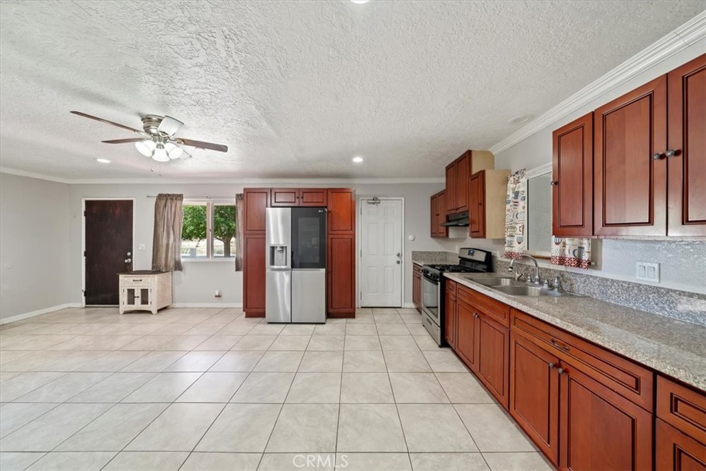 20548 Neuralia Road California City, CA 93505 - Photo 24 of 49 a large kitchen with stainless steel appliances granite countertop a stove a sink dishwasher and a refrigerator