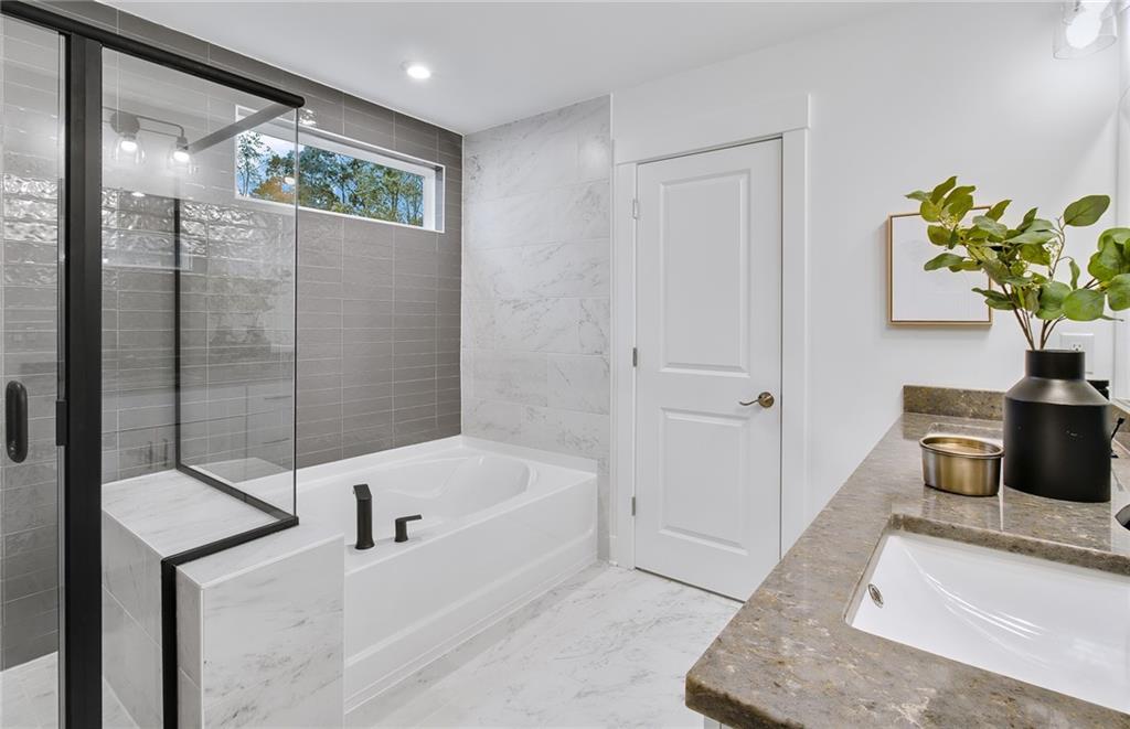 303 Rockledge Bend Southwest Powder Springs, GA 30127 - Photo 14 of 18 a bathroom with a tub sink and mirror