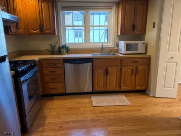 a kitchen with granite countertop a sink cabinets and a stove top oven