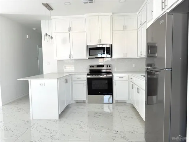 a kitchen with a white stove top oven and white cabinets