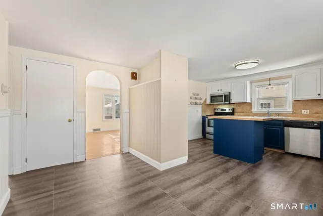 a view of kitchen with wooden floor and electronic appliances