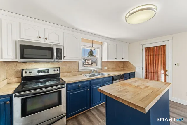 a kitchen with stainless steel appliances granite countertop a stove a sink and a microwave