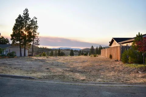 a dirt road with a building in the background