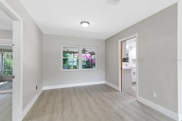 a view of hallway with window and wooden floor