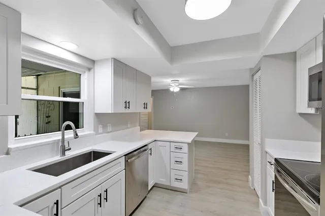 a kitchen with a sink stove and cabinets