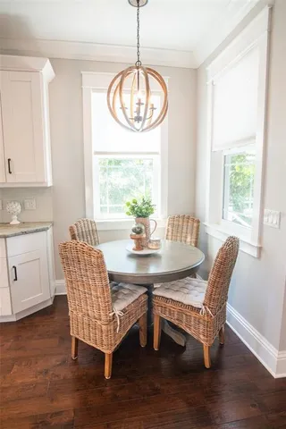 a kitchen with stainless steel appliances granite countertop a stove a sink dishwasher a dining table and chairs with wooden floor