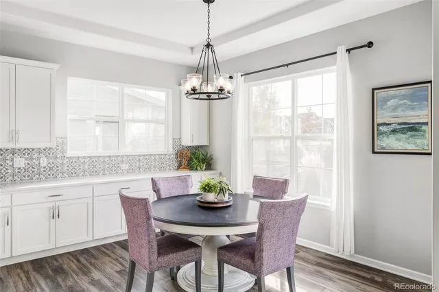 a dining room with furniture a chandelier and window
