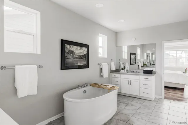 a spacious bathroom with a bathtub sink and mirror