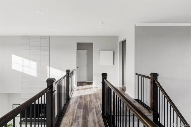 a view of a hallway with wooden floor and stairs