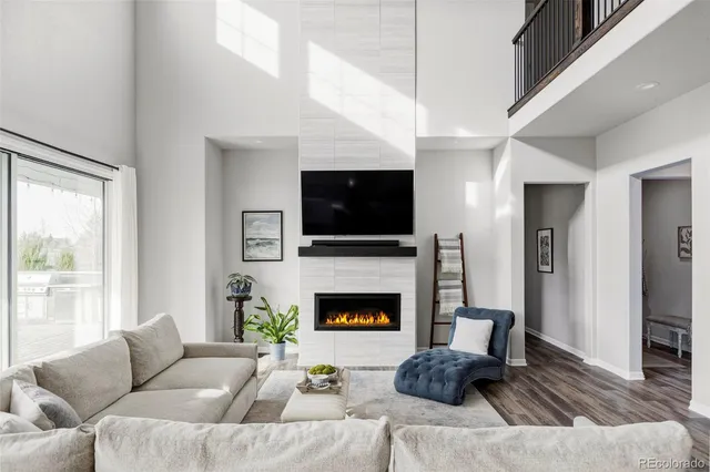 a living room with furniture a flat screen tv and a fireplace
