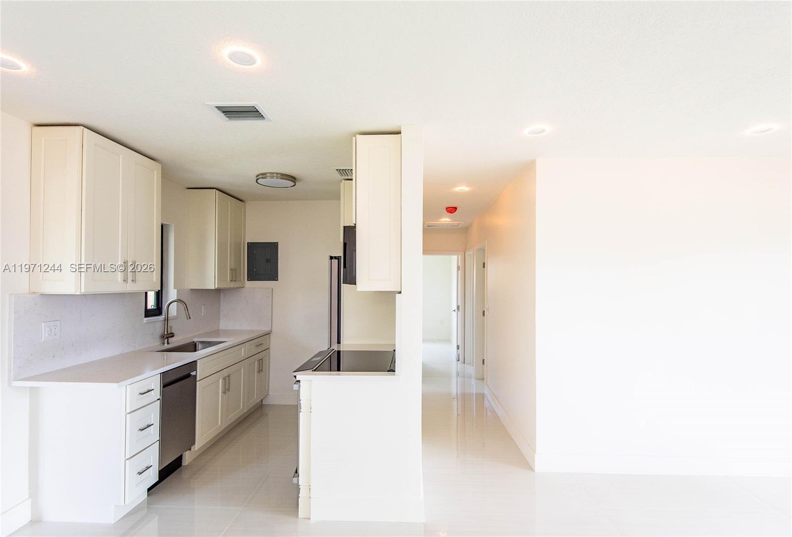 11861 Southwest 185th Terrace Miami, FL 33177 - Photo 17 of 34 a kitchen with a sink and white cabinets