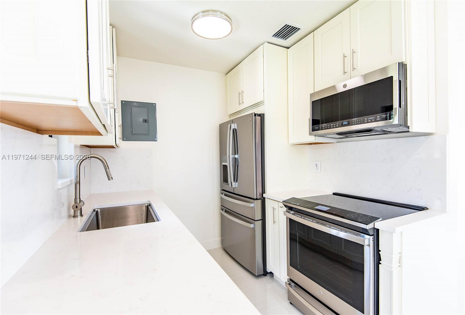 11861 Southwest 185th Terrace Miami, FL 33177 - Photo 18 of 34 a kitchen with stainless steel appliances a microwave sink and refrigerator