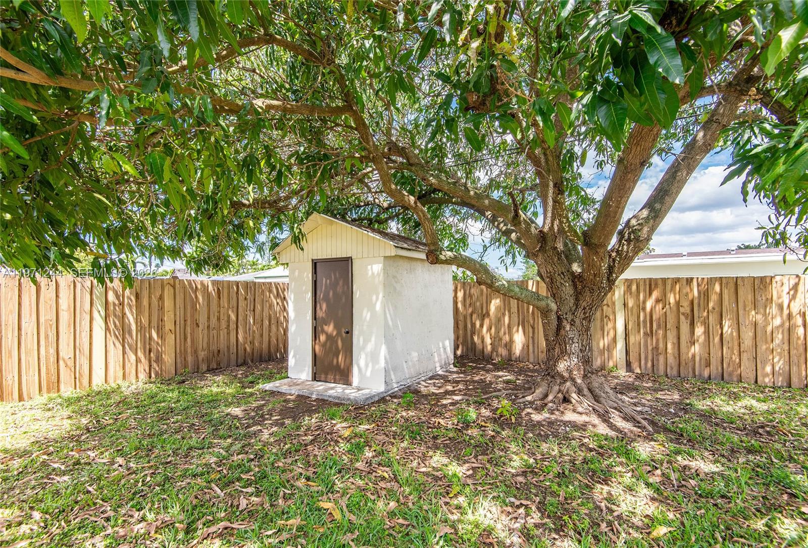 11861 Southwest 185th Terrace Miami, FL 33177 - Photo 10 of 34 a backyard of a house with a large tree and wooden fence