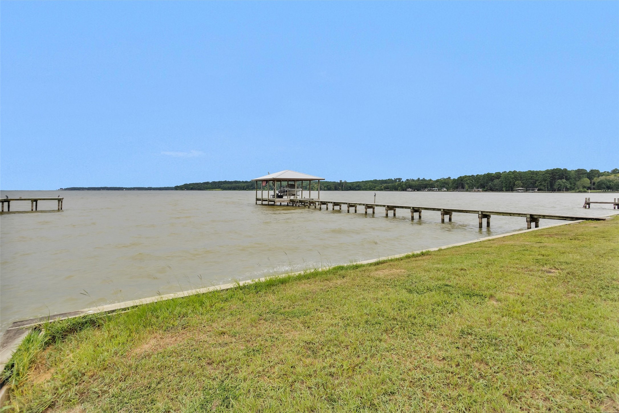 270 Johnson Road Coldspring, TX 77331 - Photo 8 of 26 Expansive waterfront view featuring a private 85 ft pier and covered dock, perfect for enjoying serene lake living.