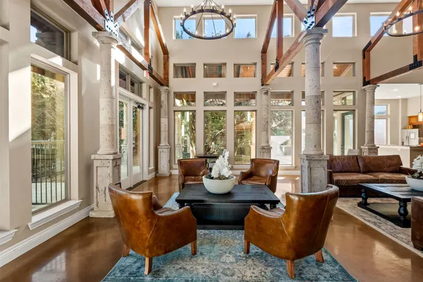 a living room with furniture a large window and a chandelier