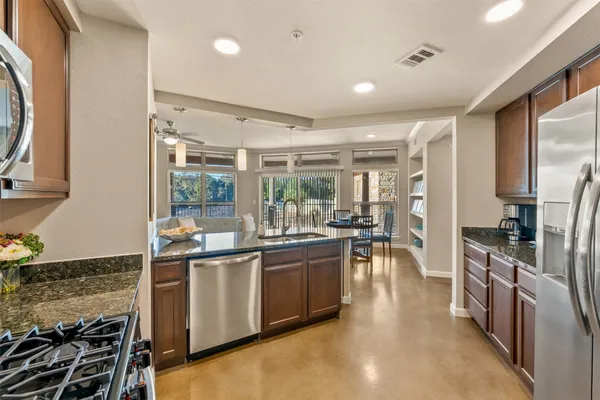 a kitchen with stainless steel appliances granite countertop a stove and a refrigerator