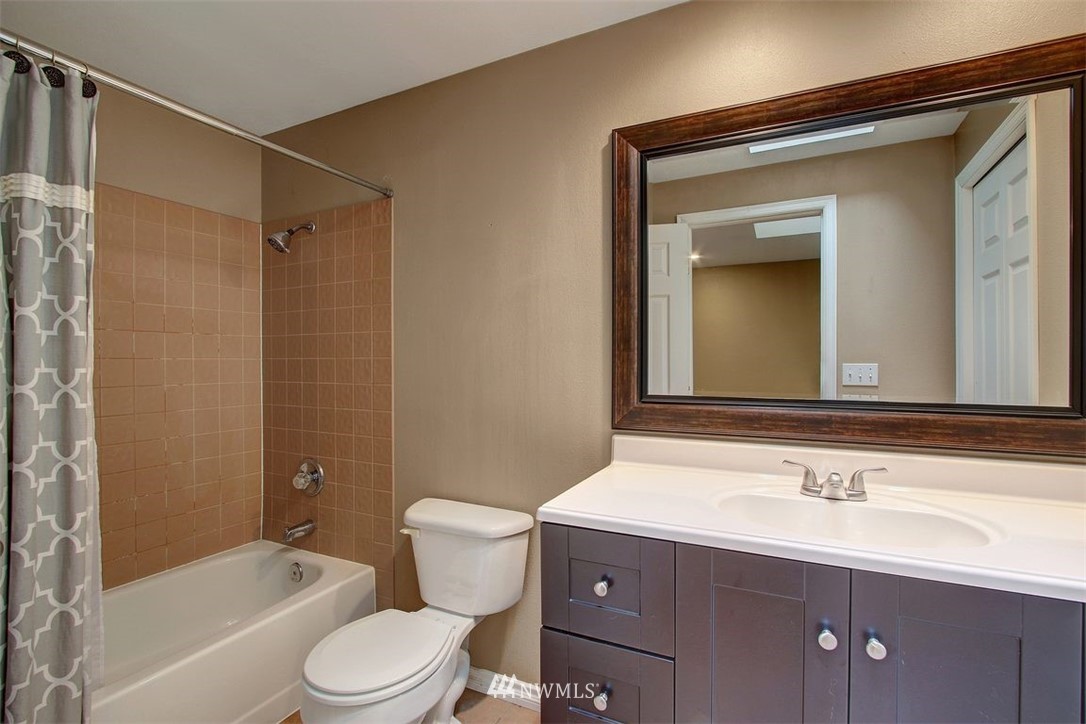 2227 Southeast 8th Place Renton, WA 98057 - Photo 12 of 21 a bathroom with a toilet a sink a mirror a bathtub and shower