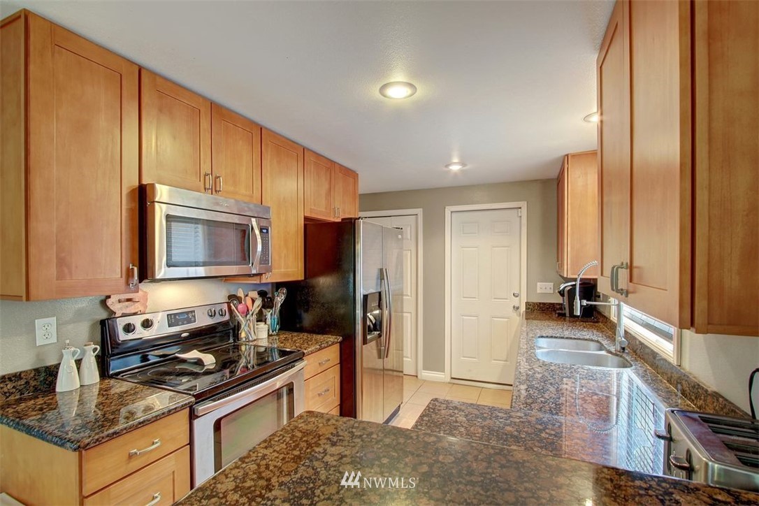 2227 Southeast 8th Place Renton, WA 98057 - Photo 8 of 21 a kitchen with stainless steel appliances granite countertop a stove a sink and a refrigerator