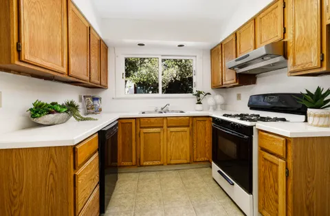 a kitchen with stainless steel appliances granite countertop a sink a stove and a microwave