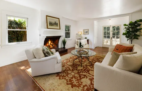 a living room with furniture a large window and a fireplace