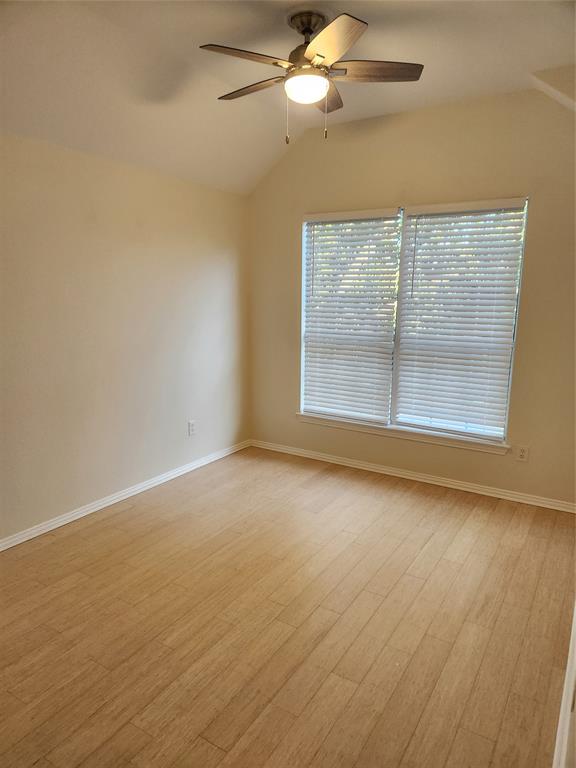 4175 Midrose Trail Dallas, TX 75287 - Photo 11 of 14 Bedroom 2. Spacious room featuring wood-finish flooring, vaulted ceilings, and a ceiling fan with integrated lighting