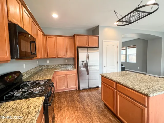 a kitchen with granite countertop wooden cabinets and a stove