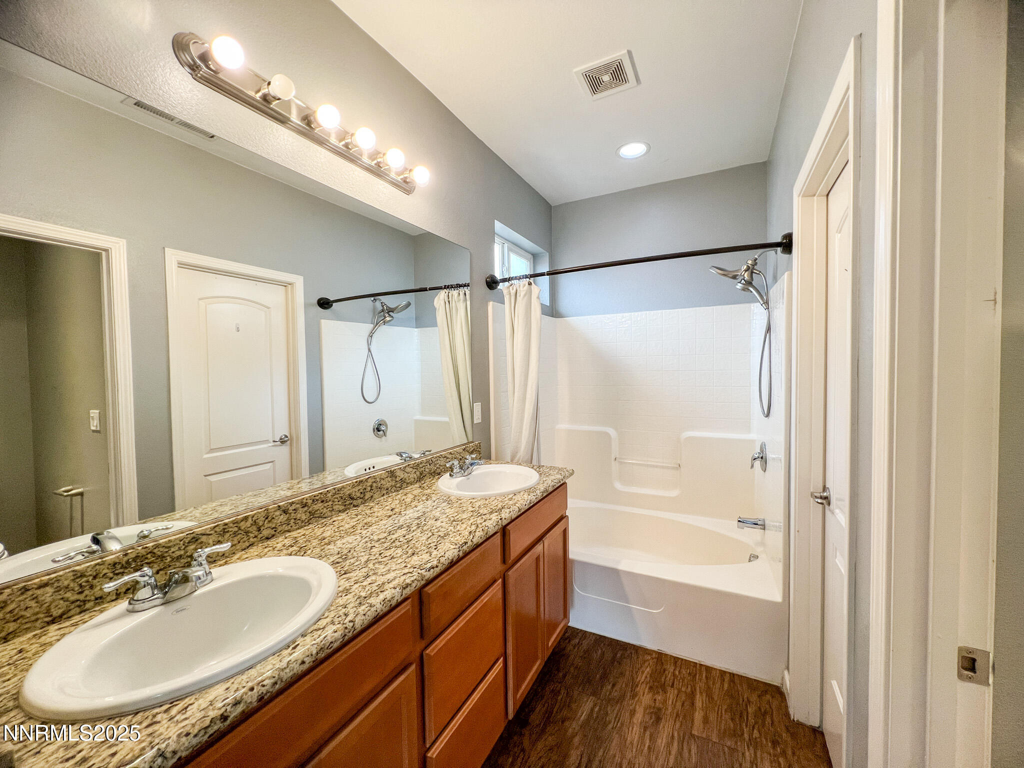 147 Walnut Drive Fernley, NV 89408 - Photo 18 of 31 a bathroom with a granite countertop sink a mirror a bathtub and shower